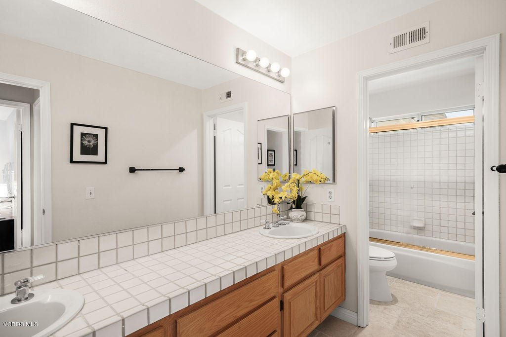2607 Riata Court Camarillo, CA 93012 - Photo 29 of 54 a bathroom with a granite countertop sink a toilet and shower