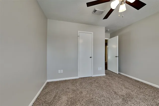 an empty room with chandelier fan