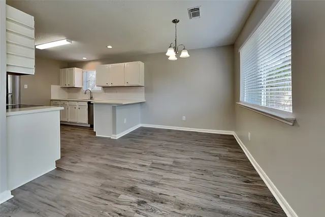 a view of a kitchen with granite countertop stove top oven and cabinets
