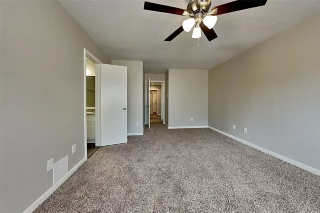 an empty room with chandelier fan