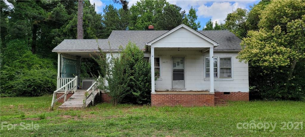 a view of a house with a yard and sitting area