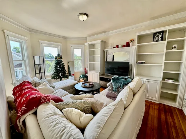 a living room with furniture a flat screen tv and a fireplace