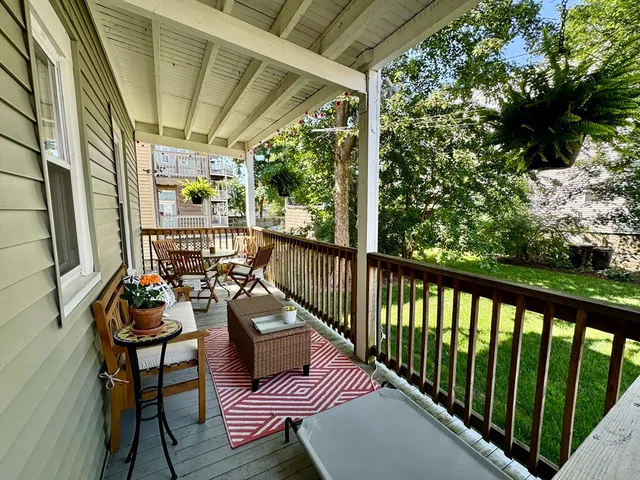 a balcony with wooden floor and outdoor seating