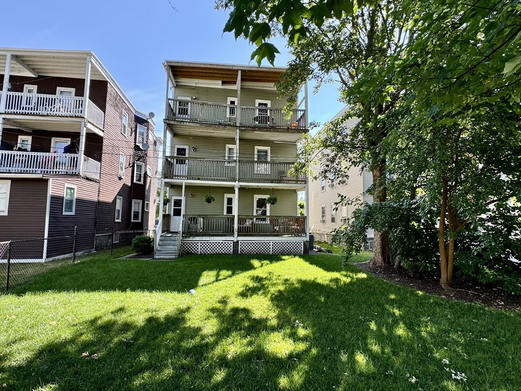 11 Wainwright Street, Unit 3 Boston, MA 02124 - Photo 19 of 26 a view of an brick house with a big yard and large trees
