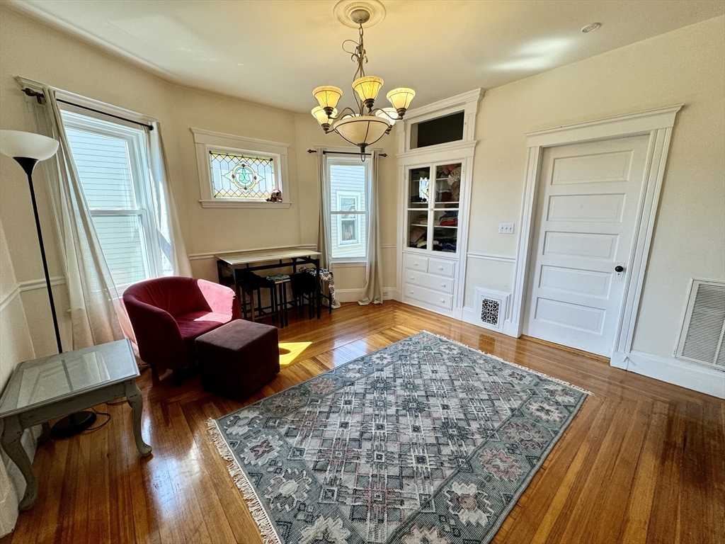 11 Wainwright Street, Unit 3 Boston, MA 02124 - Photo 3 of 26 a living room with furniture and a chandelier