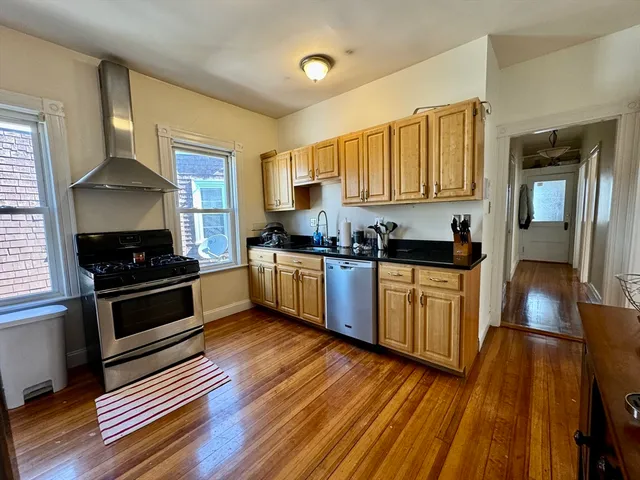 a kitchen with wooden floors and black appliances