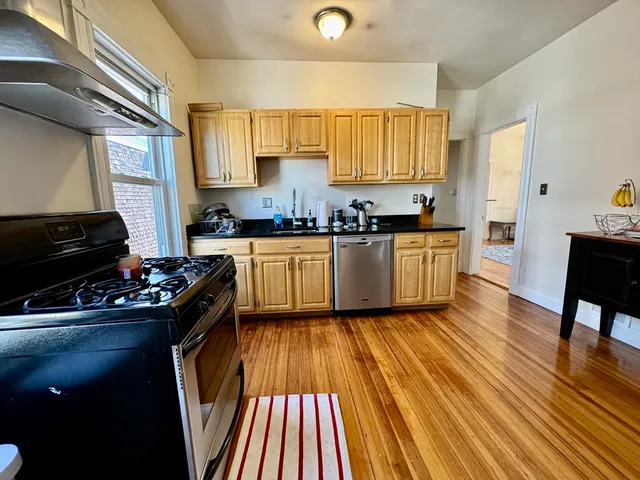 a kitchen with wooden floors and appliances