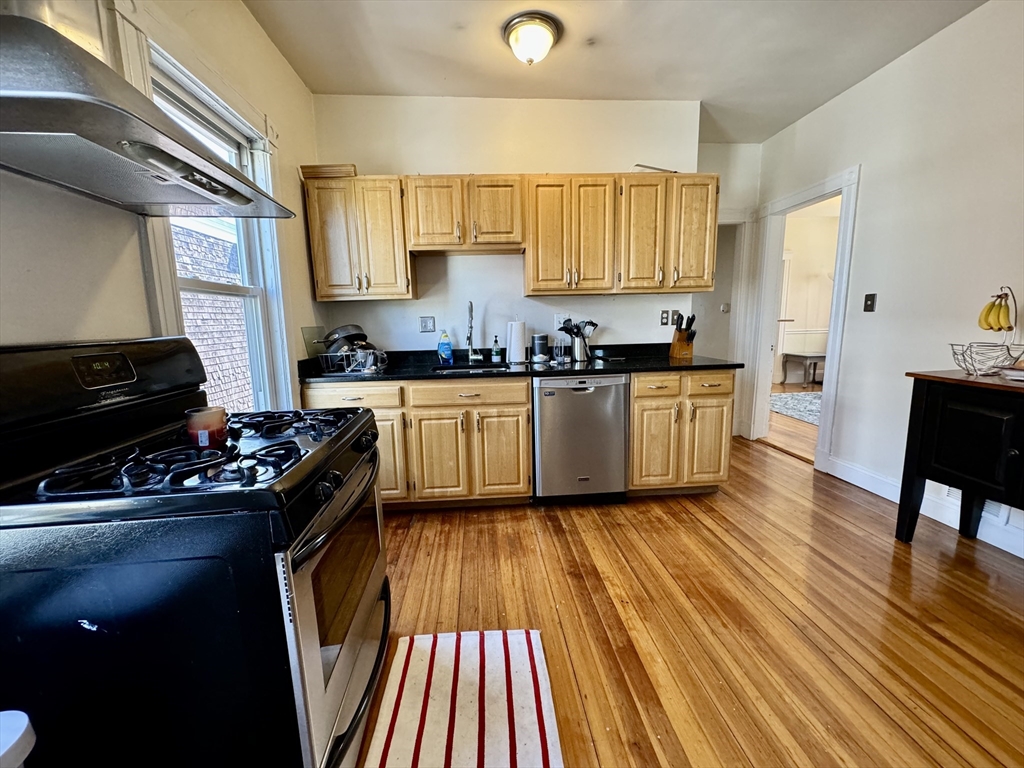 11 Wainwright Street, Unit 3 Boston, MA 02124 - Photo 7 of 26 a kitchen with wooden floors and appliances