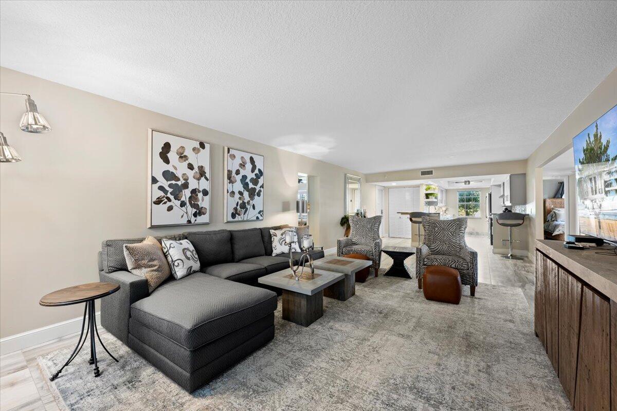 1252 Sugar Sands Boulevard, Unit 132 Riviera Beach, FL 33404 - Photo 11 of 40 a living room with furniture and a flat screen tv