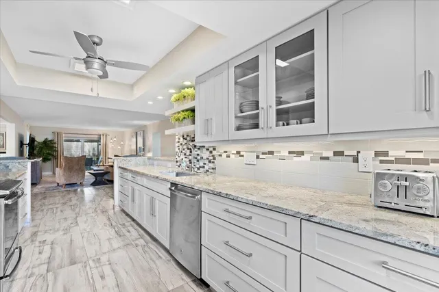 a kitchen with granite countertop a sink stainless steel appliances and cabinets