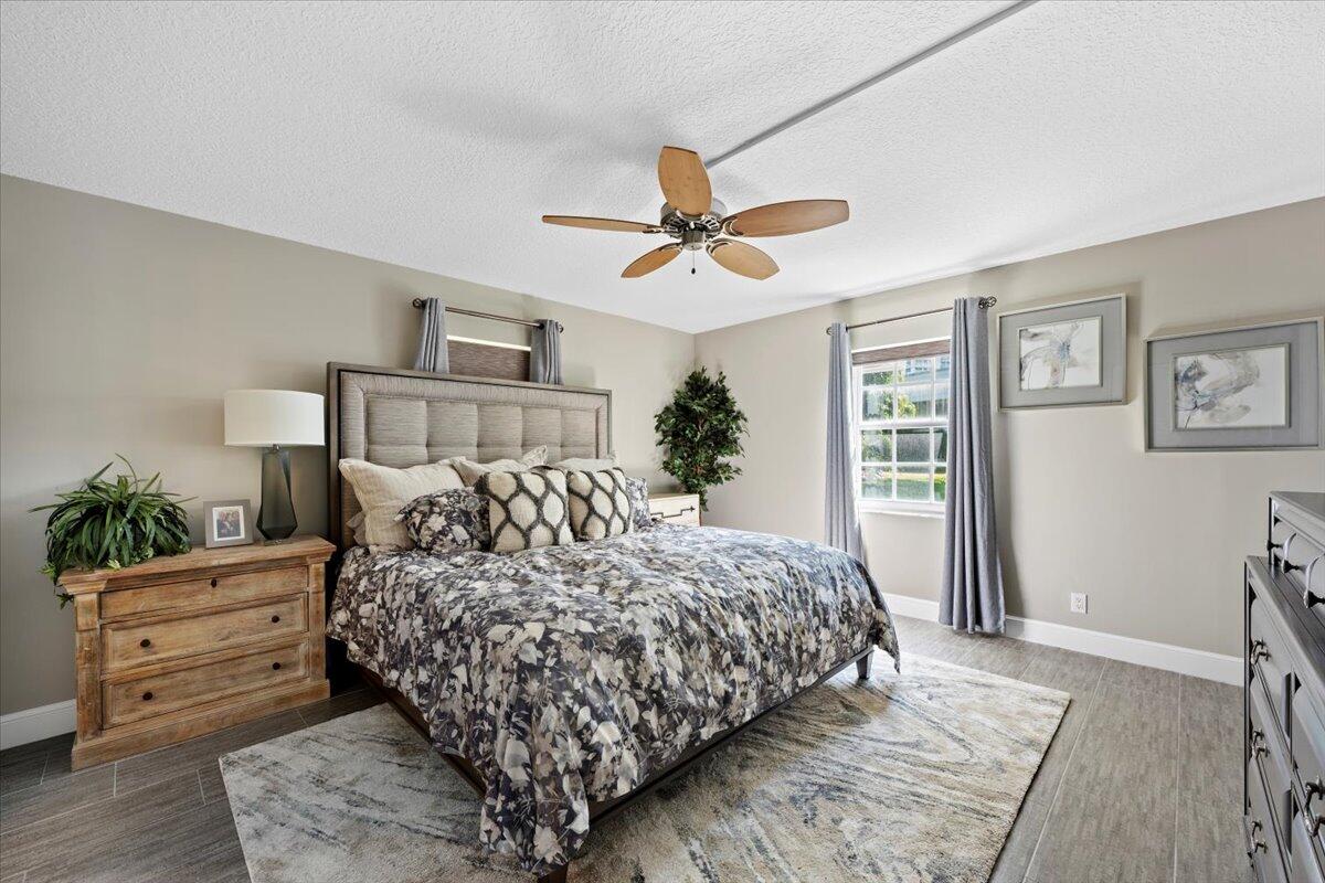 1252 Sugar Sands Boulevard, Unit 132 Riviera Beach, FL 33404 - Photo 14 of 40 a bedroom with a large bed and a chandelier
