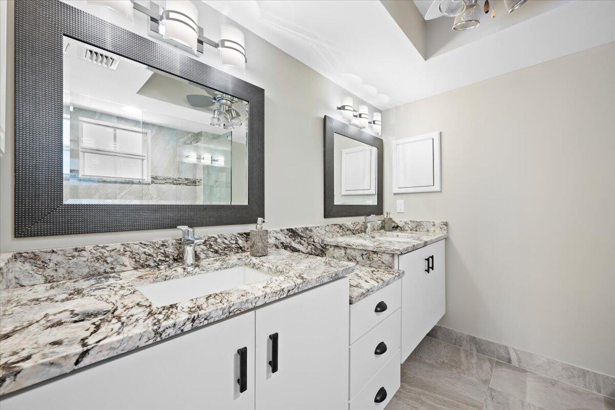 1252 Sugar Sands Boulevard, Unit 132 Riviera Beach, FL 33404 - Photo 16 of 40 a bathroom with a granite countertop sink and a mirror