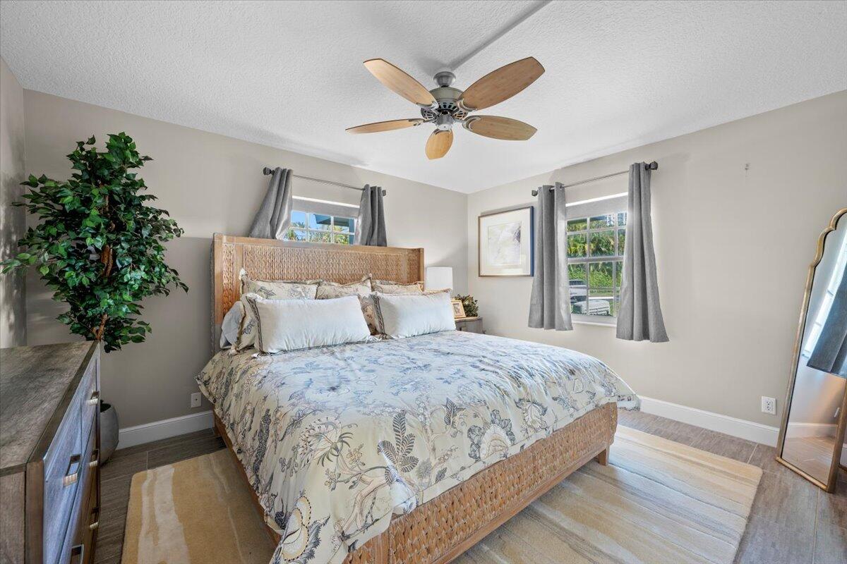 1252 Sugar Sands Boulevard, Unit 132 Riviera Beach, FL 33404 - Photo 19 of 40 a bedroom with a large bed and a chandelier