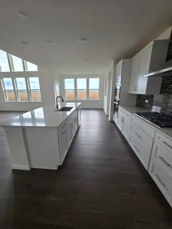 a large kitchen with counter top space and stainless steel appliances