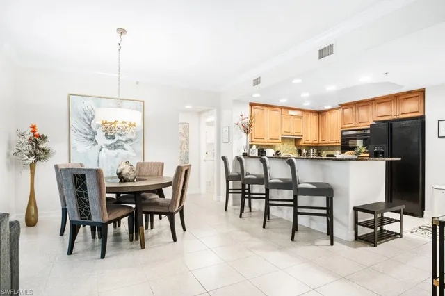 a view of kitchen with refrigerator dining table and chairs
