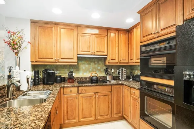 a kitchen with stainless steel appliances granite countertop a sink a stove and a microwave