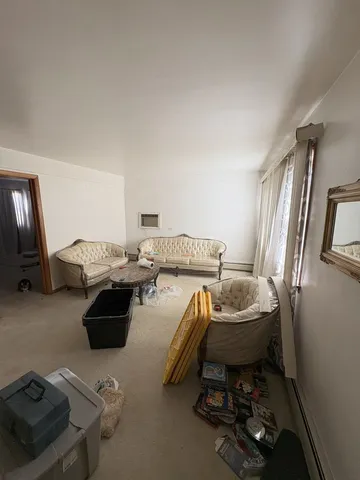 a living room with furniture a flat screen tv and a window