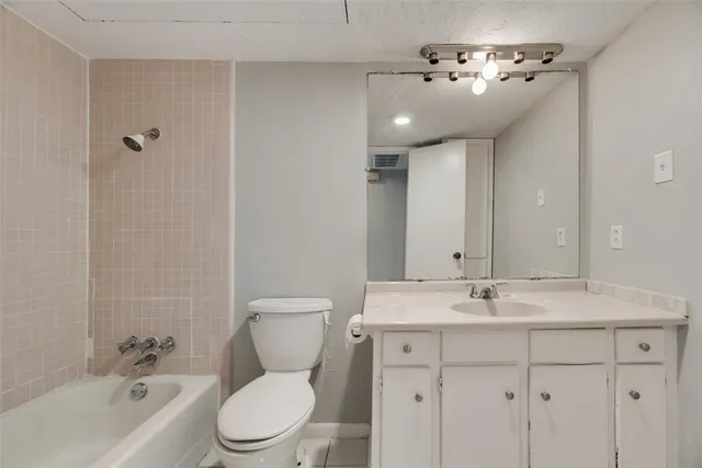 a bathroom with a toilet a sink a tub and mirror