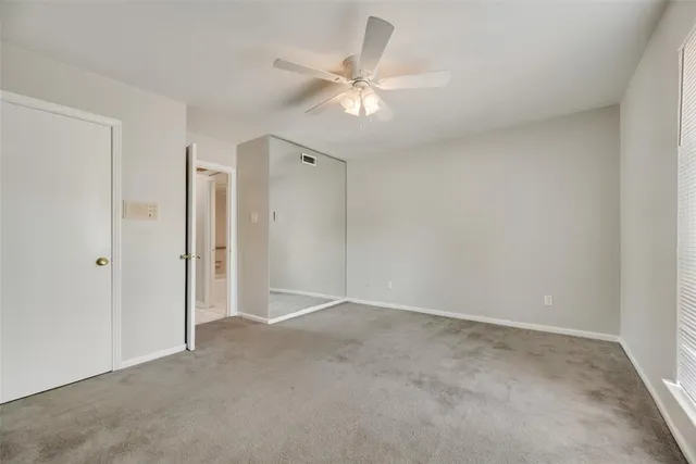 a view of an empty room with a ceiling fan