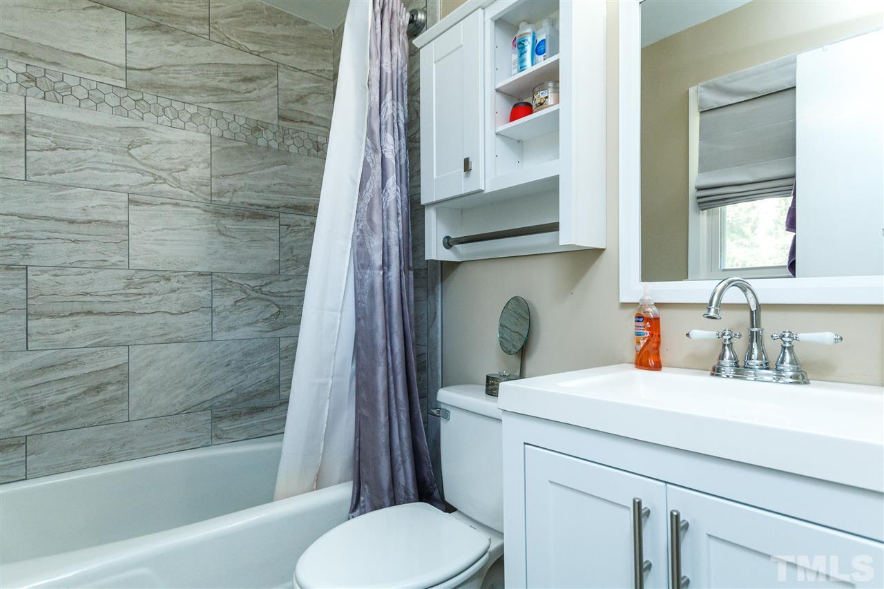 5220 Revere Road Durham, NC 27713 - Photo 22 of 30 a bathroom with a sink toilet and shower