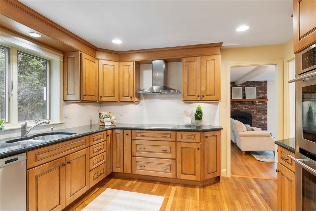 244 Hunters Ridge Road Concord, MA 01742 - Photo 13 of 41 a kitchen with stainless steel appliances granite countertop a stove a sink and a granite counter tops with wooden floors