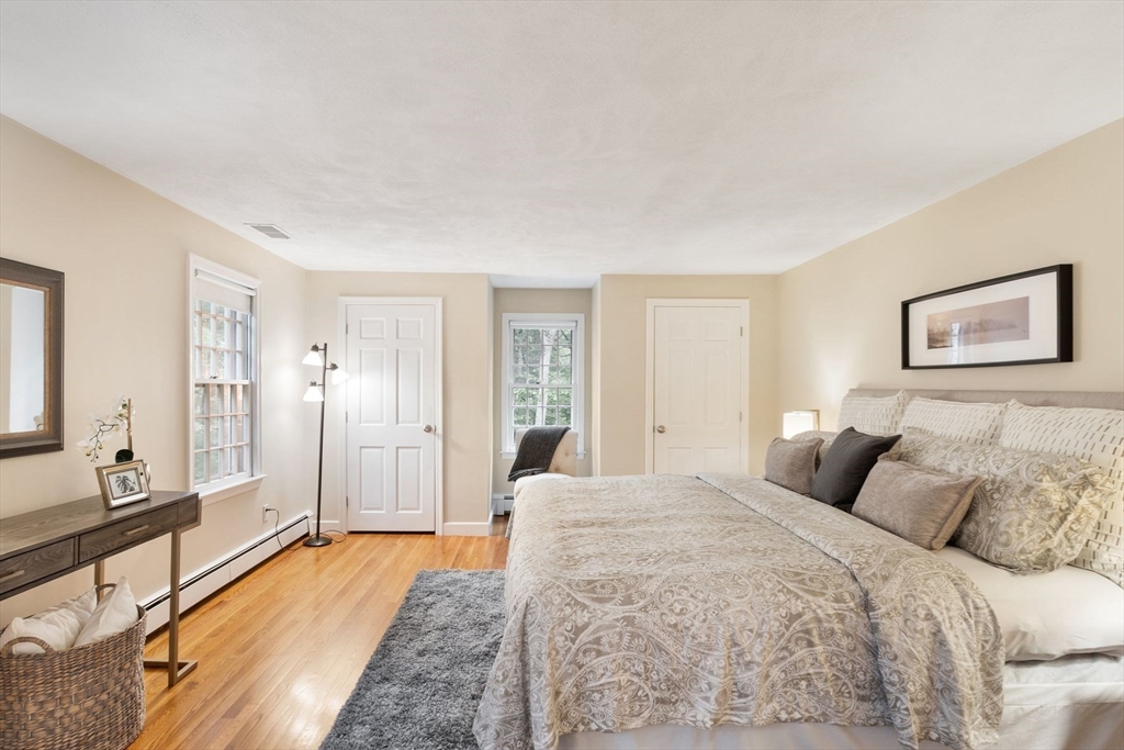 244 Hunters Ridge Road Concord, MA 01742 - Photo 23 of 41 a bedroom with a large bed a rug and painting on the wall
