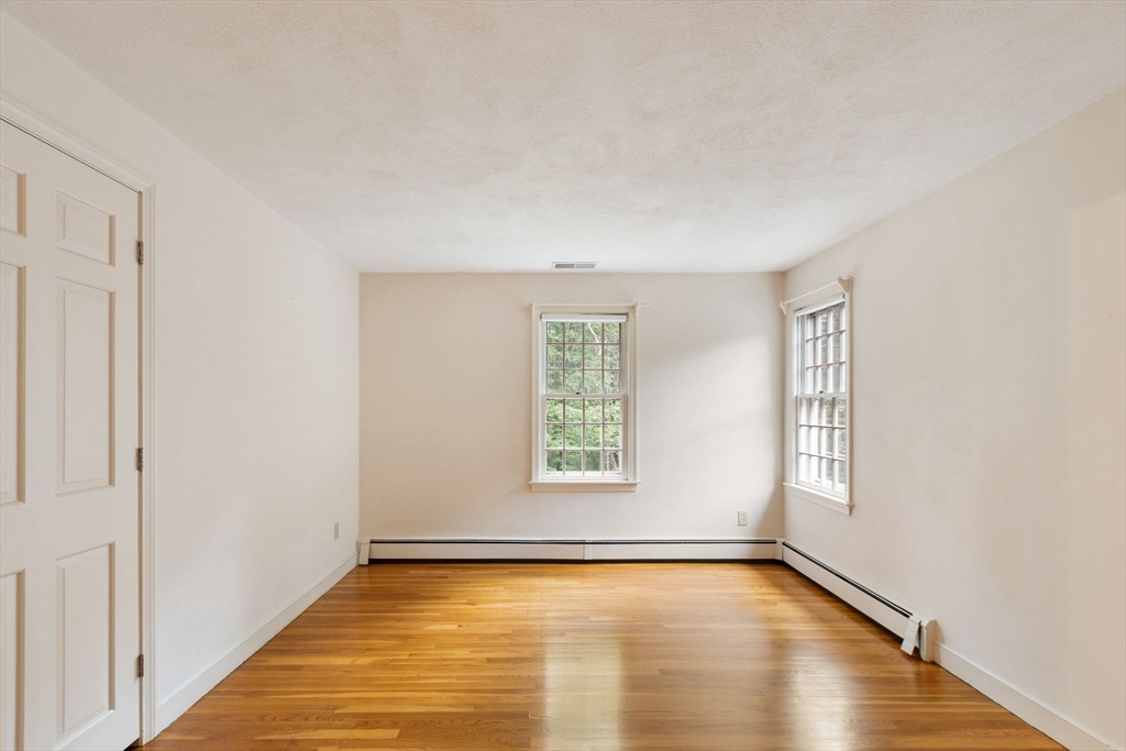 244 Hunters Ridge Road Concord, MA 01742 - Photo 31 of 41 a view of an empty room with window and wooden floor