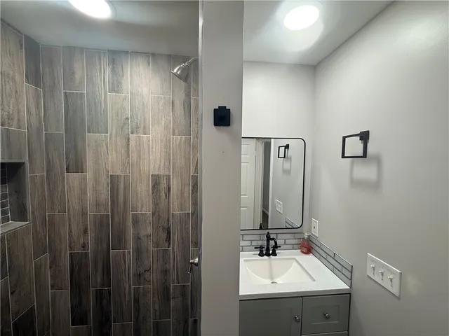 a bathroom with a sink a mirror and shower