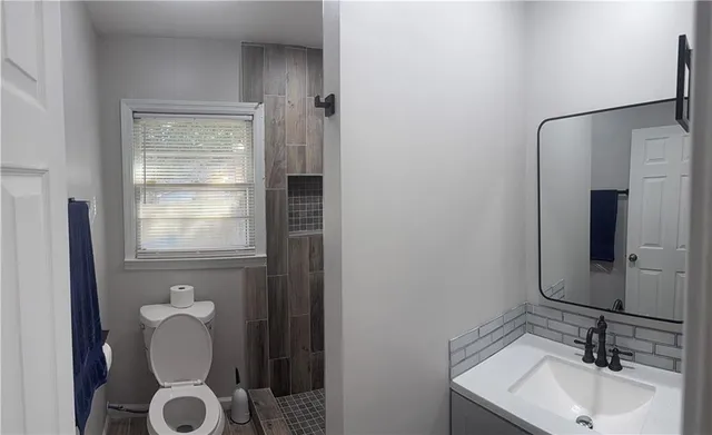a bathroom with a sink and mirror with bathtub