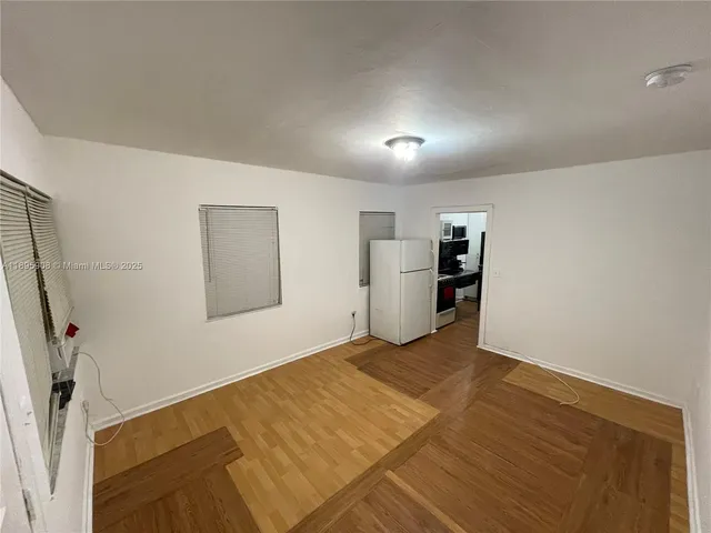 an empty room with wooden floor and mirror