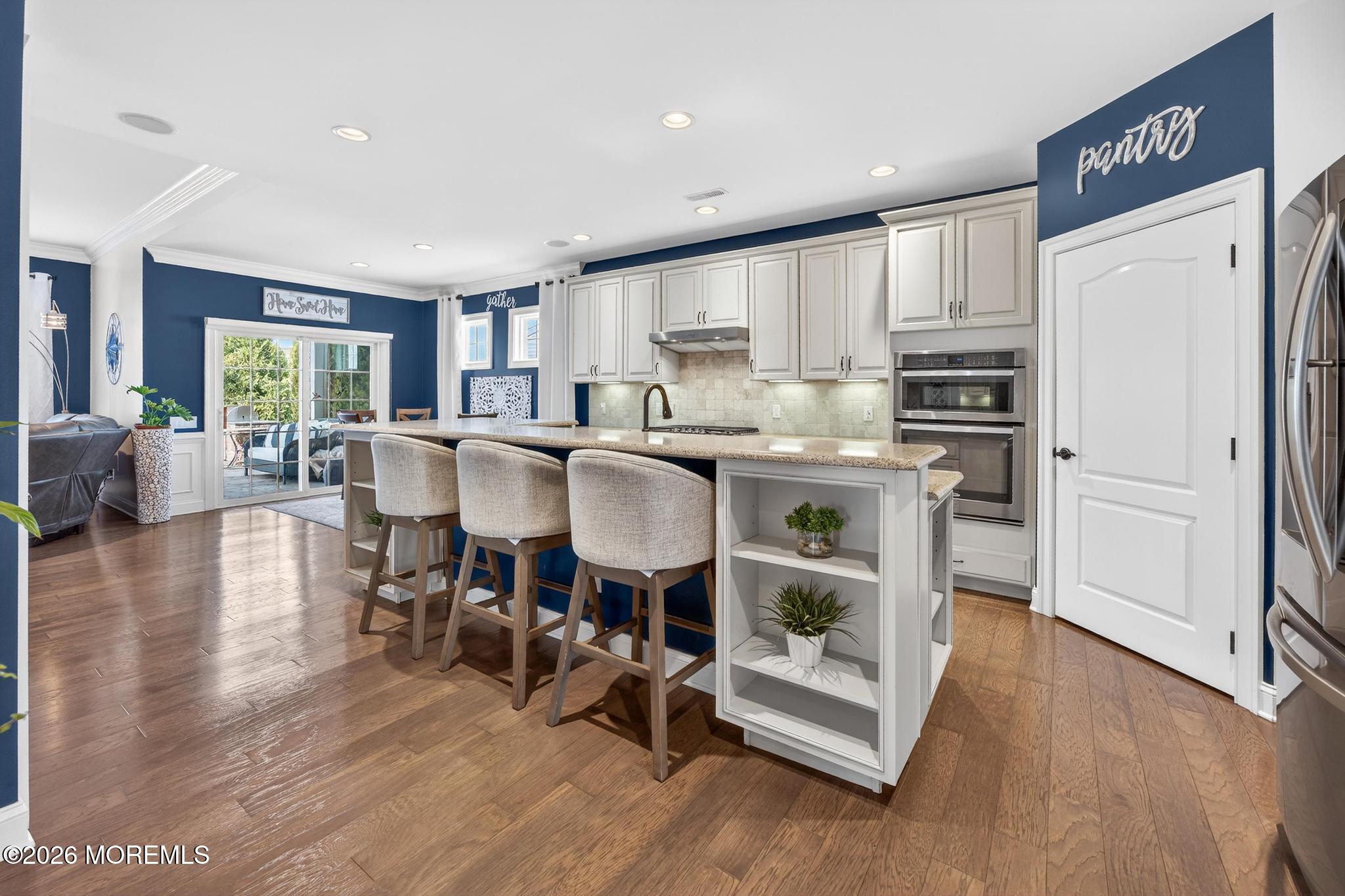 35 Addlestone Lane Manchester Township, NJ 08759 - Photo 10 of 44 a kitchen with stainless steel appliances granite countertop a refrigerator a stove a sink dishwasher and a dining table with wooden floor