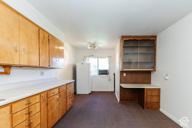 3959 Main Street Logan, UT 84321 - Photo 10 of 35 Kitchen featuring wood cabinetry, white countertops, built-in desk, and display shelving