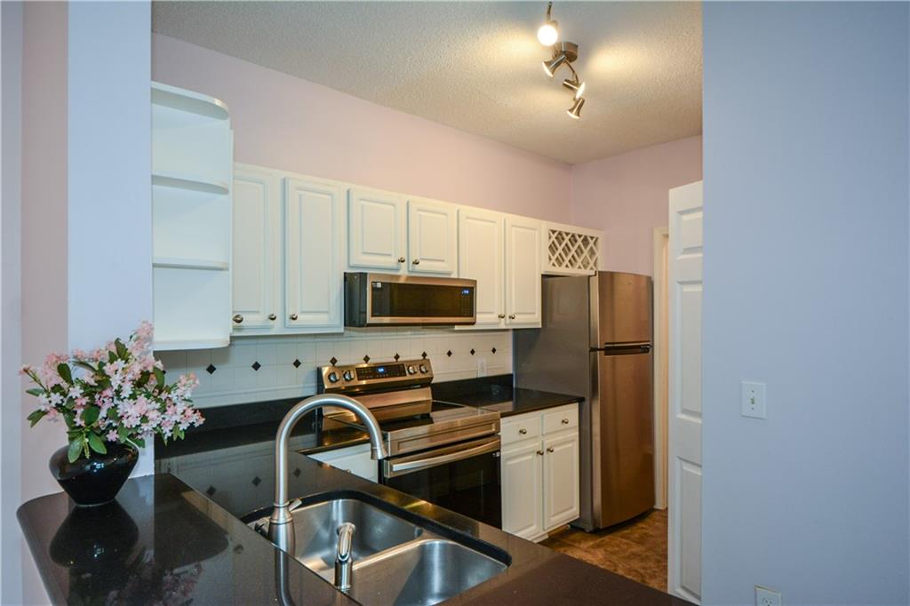 a kitchen with stainless steel appliances a refrigerator sink microwave and cabinets