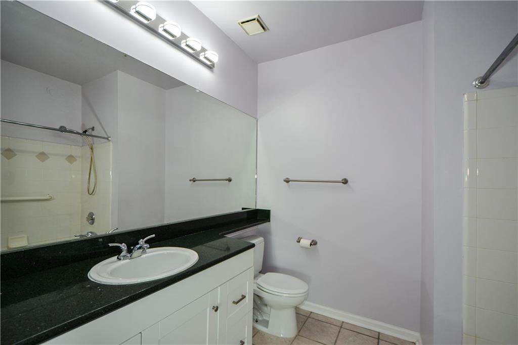 955 Juniper Street Northeast, Unit 4112 Atlanta, GA 30309 - Photo 20 of 27 a bathroom with a granite countertop sink and a mirror with toilet