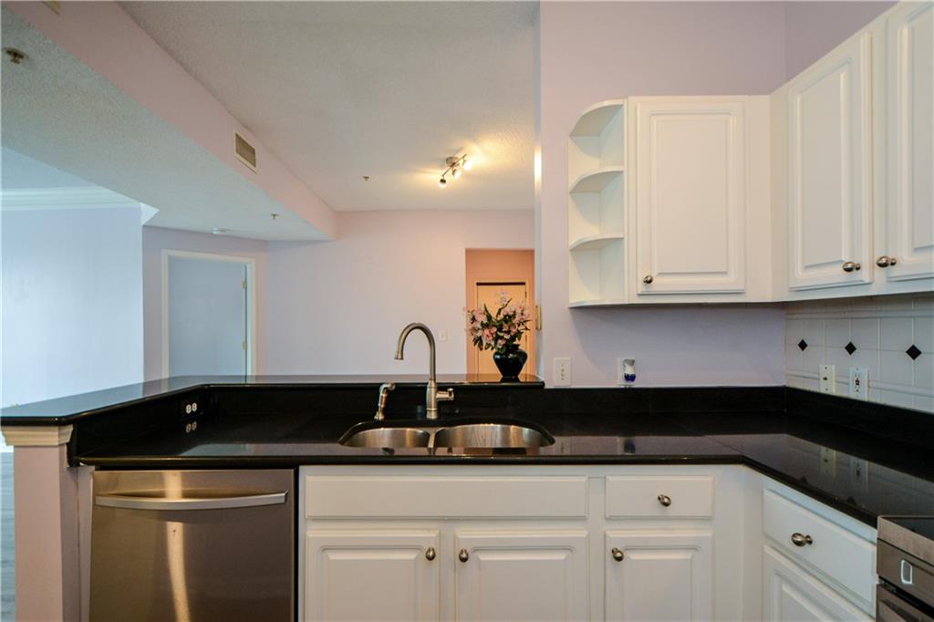 955 Juniper Street Northeast, Unit 4112 Atlanta, GA 30309 - Photo 10 of 27 a kitchen with granite countertop white cabinets and a sink