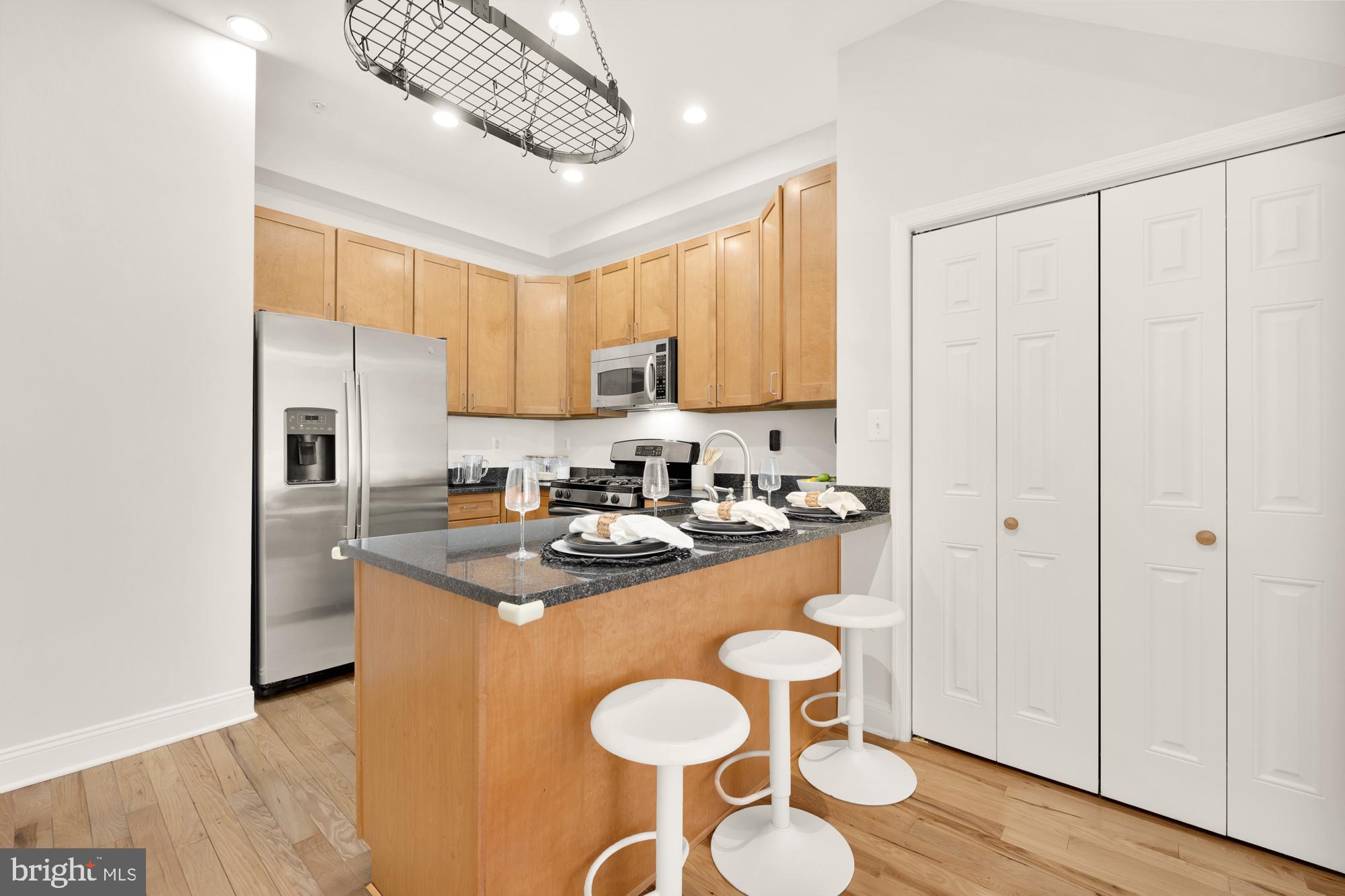 2713 Ontario Road Northwest, Unit 2 Washington, DC 20009 - Photo 9 of 33 a kitchen with stainless steel appliances granite countertop a sink a stove a refrigerator cabinets and wooden floor