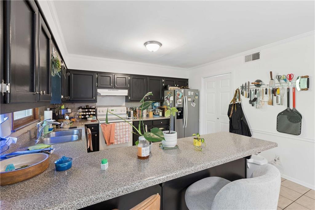 795 North Parkwood Road Decatur, GA 30030 - Photo 29 of 50 a kitchen with a table chairs and white cabinets