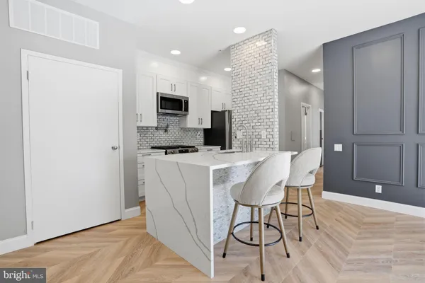 a kitchen with a table chairs refrigerator and microwave