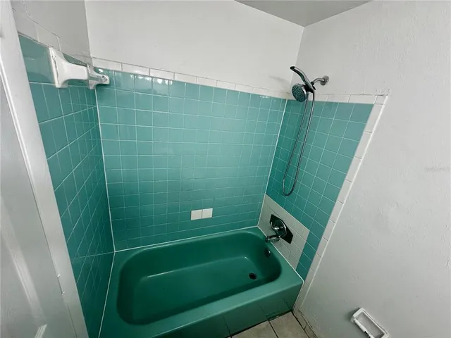 a bathroom with green tub a sink and toilet