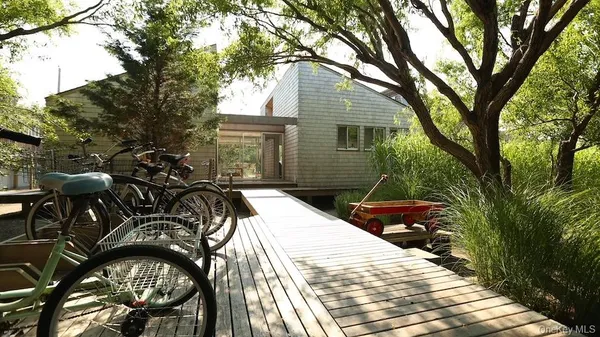 a view of a patio with table and chairs with plants and trees