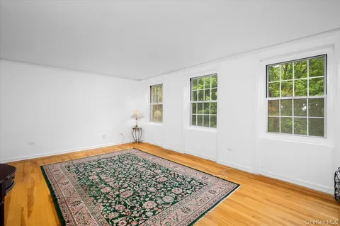an empty room with wooden floor and a window