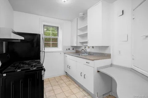 a kitchen with granite countertop a stove sink and cabinets