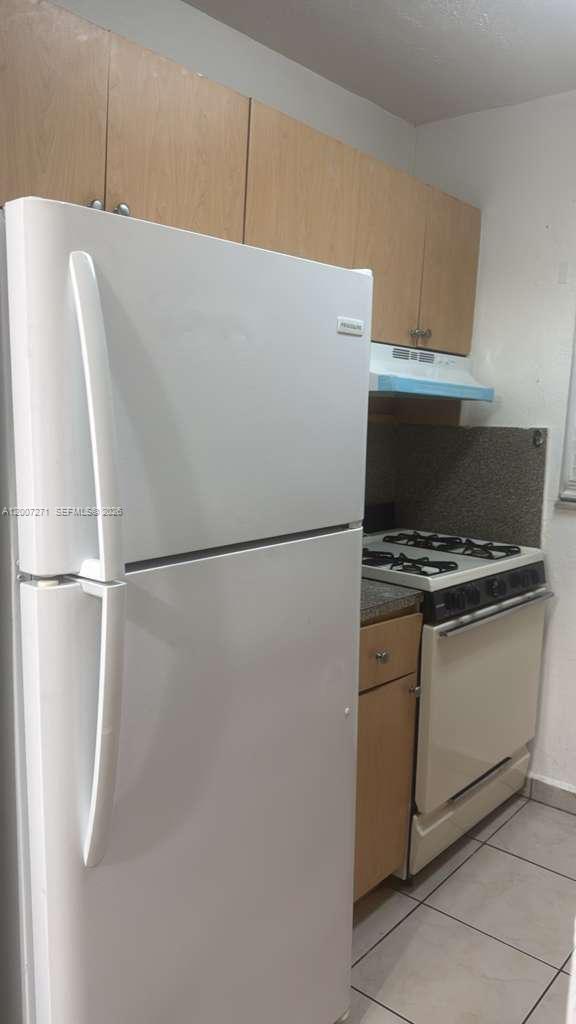 1655 West 44th Place, Unit 451 Hialeah, FL 33012 - Photo 1 of 12 a white refrigerator freezer and a stove sitting inside of a kitchen