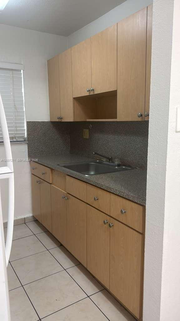 1655 West 44th Place, Unit 451 Hialeah, FL 33012 - Photo 6 of 12 a kitchen with granite countertop white cabinets and white appliances