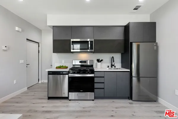 a kitchen with stainless steel appliances a refrigerator stove and microwave