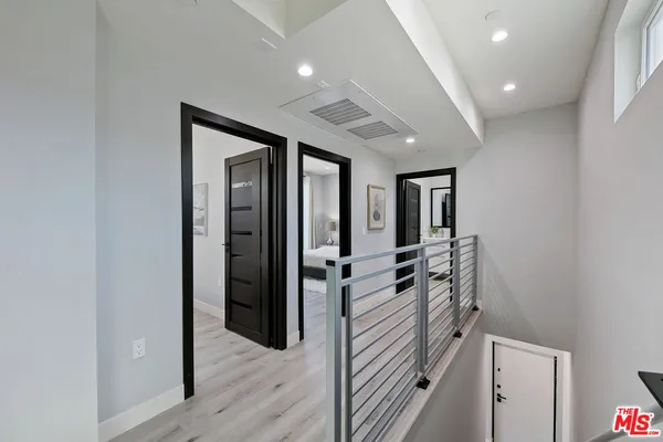 a hallway with a large mirror and dresser