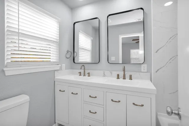 a bathroom with a double vanity sink mirror and