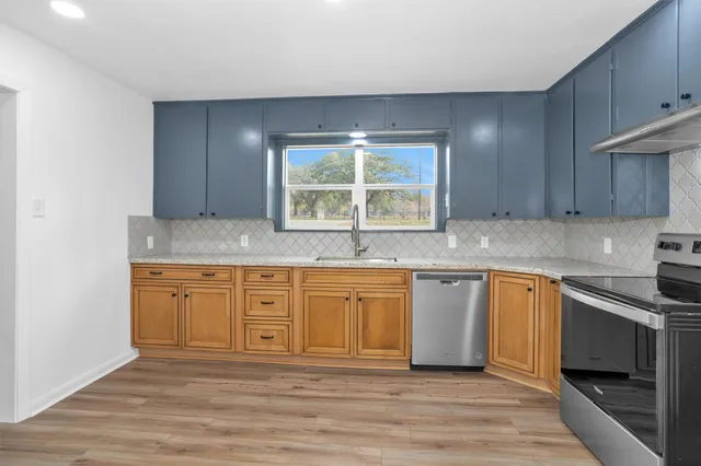 a kitchen with granite countertop cabinets stainless steel appliances and a sink