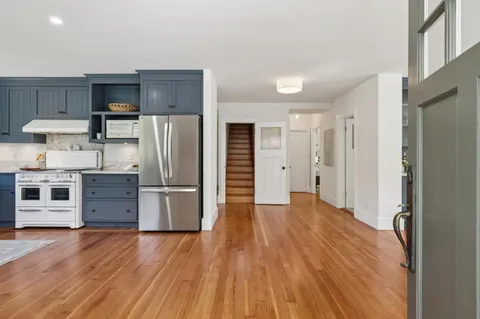 a kitchen with stainless steel appliances a refrigerator and wooden floor