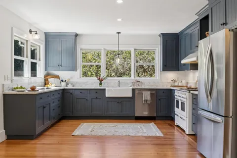 a bathroom with a granite countertop sink and a window